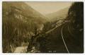 Postcard: [Postcard of Man Sitting on Railroad Track Cliff]