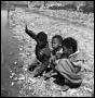 Photograph: [Three Children Kneeling on a Rocky Bank]