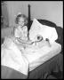 Photograph: Governor Shivers' daughter on bed with stuffed dog