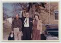 Photograph: [Photograph of Cleve, Oscar, and Emma Back by a House]