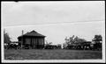 Primary view of [Photograph of  the wooden cabin surrounded by a large number of automobiles]