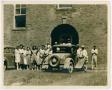 Primary view of [Photograph of People Beside Automobiles Outside Brick Building]