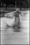 Photograph: [Boy Riding Bike in Flooded Street]