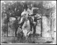 Photograph: [Cowboy participating in bull riding event at a rodeo]