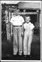 Photograph: [Albert Lee Linke and Glen Roy Linke standing in front of their home]