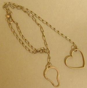 Primary view of object titled '[Silver chain with a hollowed heart charm]'.