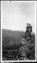 Photograph: [Two men standing on the edge of a rock cliff overlooking a city]