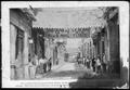Photograph: [A street scene with people on the left and right street sidewalks]