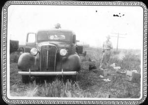 Primary view of object titled '[Men working in the rice field around a truck at the George Ranch]'.