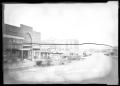 Primary view of [Photograph of a Row of Businesses and Automobiles]
