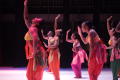 Primary view of [Ensemble in colorful costumes with an arm raised]