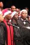 Photograph: [Choir members performing in Santa hats]