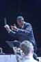 Photograph: [Orchestra director conducting, slightly smiling]
