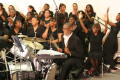 Primary view of [Drummer and choir performing on stage]