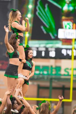 Primary view of object titled '[North Texas Cheerleaders setting up A-Frame pose]'.