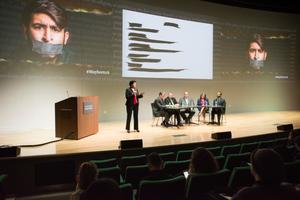Primary view of object titled '[Panelists and moderator on stage]'.