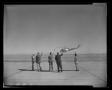 Photograph: [Photograph of five men waving at a UH-1A Iroquois helicopter]