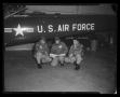 Photograph: [Photograph of three individuals posing in front of a UH-1F Iroquois …