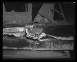 Photograph: [Photograph of parts of a wrecked aircraft on a workbench, 3]