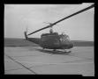 Photograph: [Photograph of a UH-1E Iroquois helicopter parked on a concrete surfa…