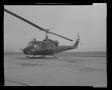 Thumbnail image of item number 1 in: '[Photograph of a UH-1B Iroquois helicopter parked outside on a concrete surface]'.
