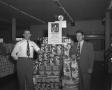 Photograph: [Portrait of Two Men with a Store Display]
