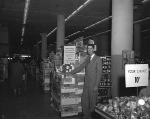 Primary view of object titled '[Man Posing With Products in a Grocery Store]'.