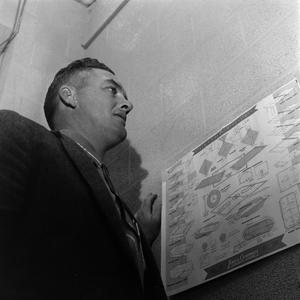Primary view of object titled '[Football coach looking at blueprints]'.