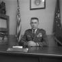 Photograph: [Lieutenant Colonel Cowles sitting at his desk]