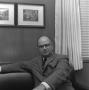 Photograph: [Dr. Kenneth Cuthbert sitting on a couch, 2]