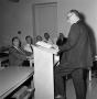Photograph: [speaker at faculty meeting]