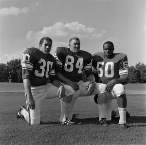 Primary view of object titled '[Three NTSU football players kneeling, 2]'.