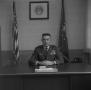 Photograph: [USAF Lieutenant Colonel Cowles seated at his desk]