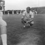 Photograph: [Football coach squatting]