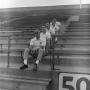 Photograph: [Football coaches sitting in a line]