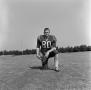 Photograph: [Football player kneeling with a ball, 16]