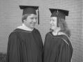 Photograph: [Two graduates smiling at each other]