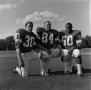 Photograph: [Three NTSU football players kneeling]