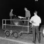 Photograph: [Men standing on a car trailer]