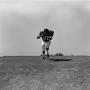 Primary view of [Football player #70, Jimmy Franklin, sprinting and starring down the camera]