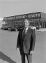 Photograph: [Man standing in front of a Pontiac-Toyota dealership, 3]