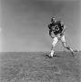 Photograph: [Football player #83, Barry Moore, running on the field]