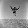 Primary view of [Football player #70, Jimmy Franklin, mid air tackle]
