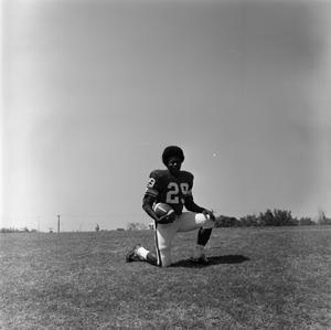 Primary view of object titled '[Football player #29, Joe Gilliam, posing on one knee cradling a football]'.