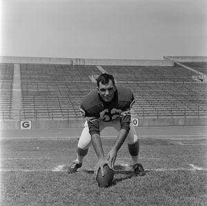 Primary view of [Football player number 52 in a three-point stance in a football field, 2]