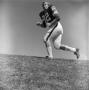 Photograph: [Football player #82, Chuck Mills, running up hill]