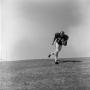 Photograph: [Football player #74, Gary Yancy, running diagonally down an incline]