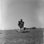 Photograph: [Football player #33, Carl Hayes, on one knee holding a football, 2]