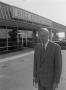 Photograph: [Man smiling in front of a Ford dealership, 5]