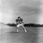 Photograph: [Football player #56, George Bray, moving to the left framed by a fla…